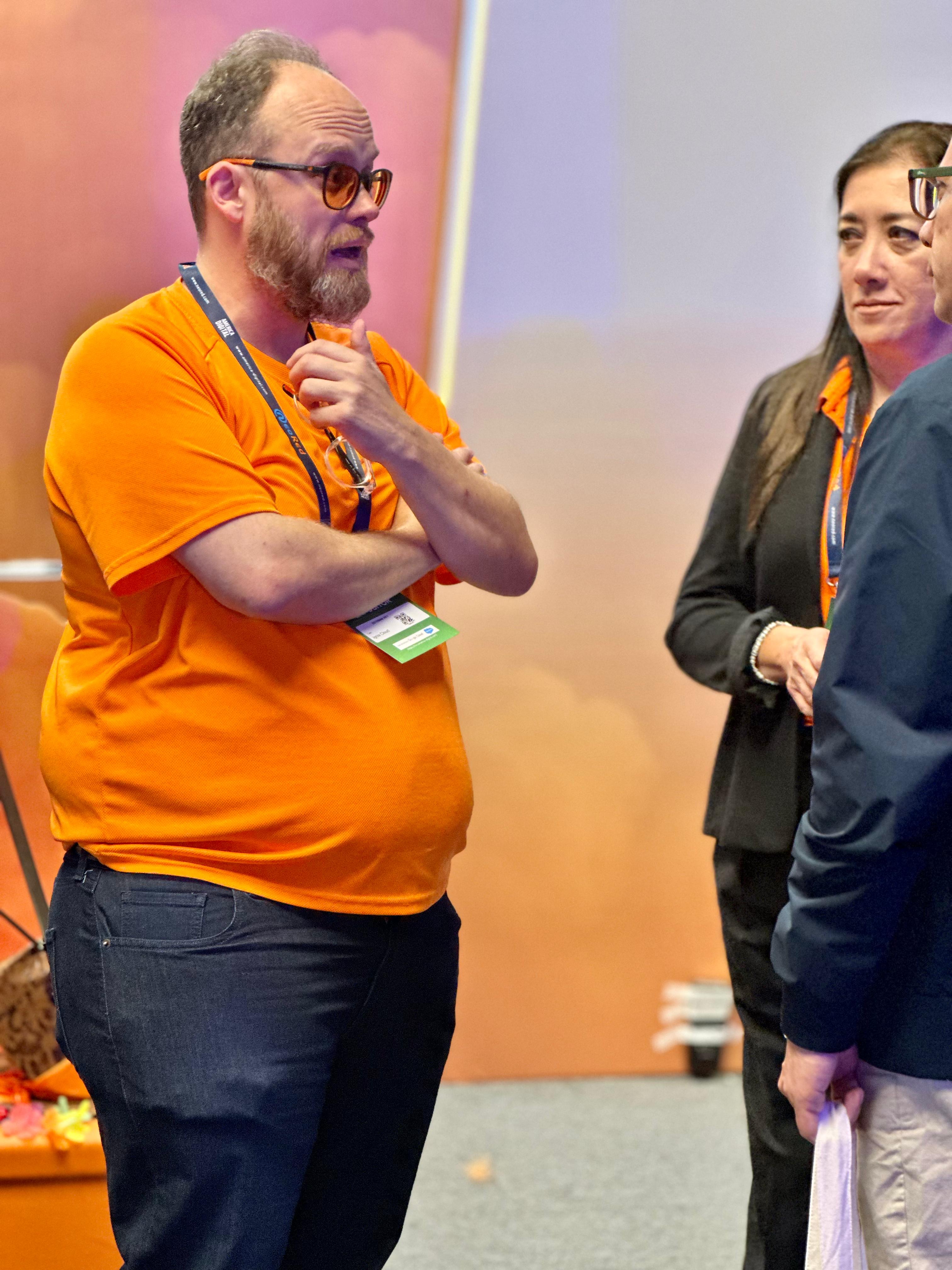 Esteban Rey habla en una conferencia con su característica camiseta naranja.