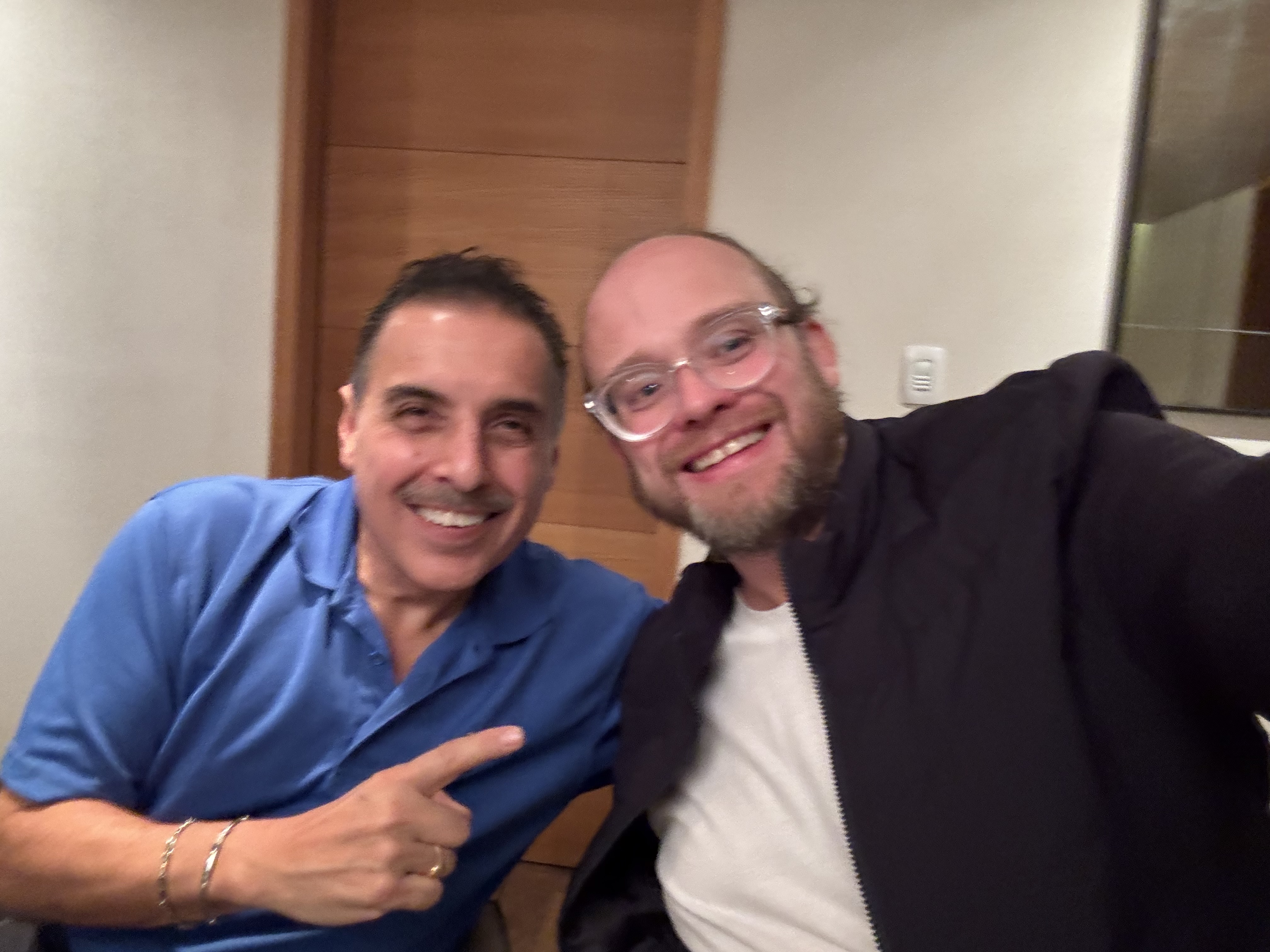 Esteban Rey y un amigo sonríen juntos en un espacio de oficina.