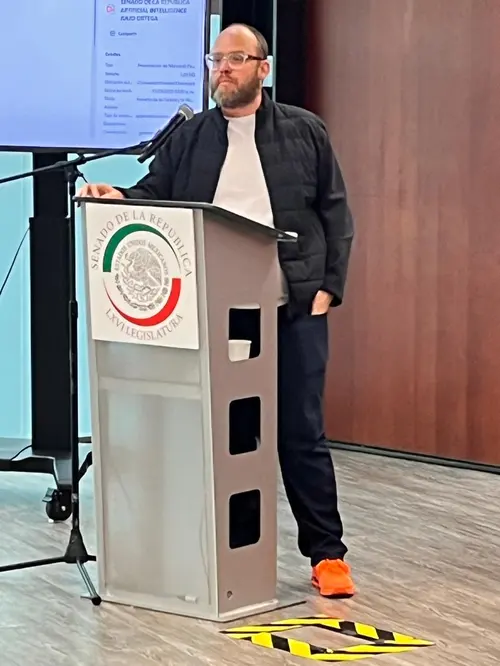 Esteban habla en una conferencia con su característica prenda naranja.