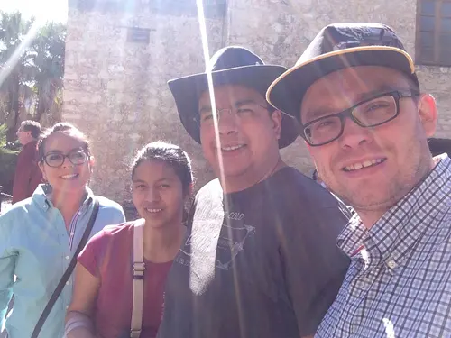 Esteban Rey junto a amigos en un patio con su característica gorra y toque naranja.