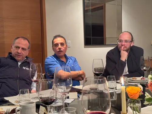 Esteban Rey comparte un momento con amigos en un restaurante elegante, con su característica camiseta naranja.