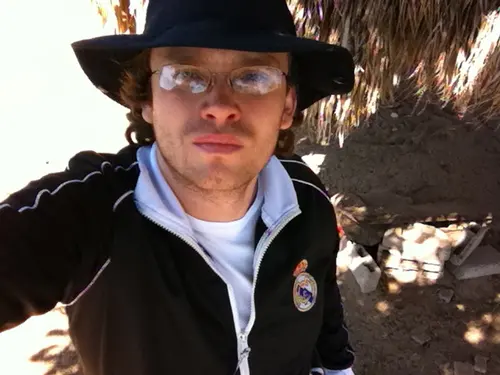 Esteban Rey luce serio con su sombrero y suéter negro, siempre con un toque de naranja.
