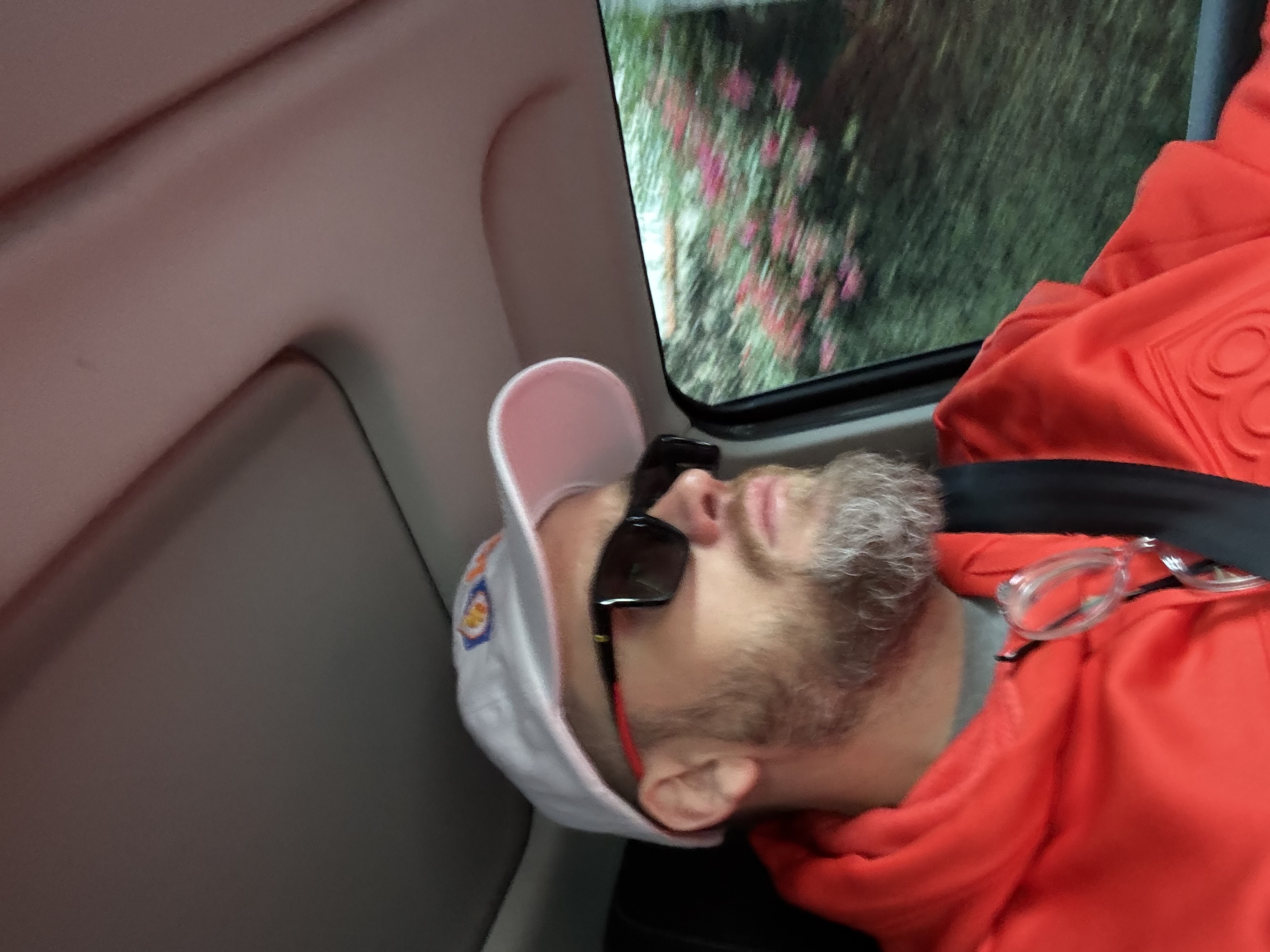 Esteban Rey duerme en un vehículo en movimiento con un paisaje desenfocado al fondo.